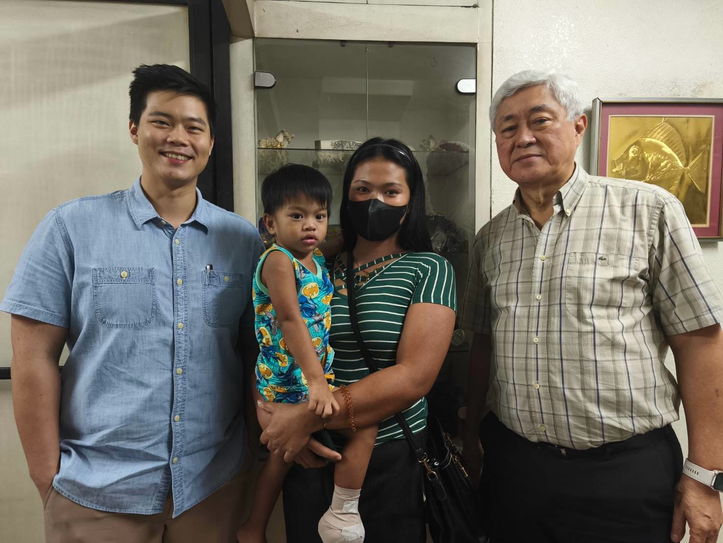 Before returning to Mindoro, Cherry Ann Aguila and her son Cyril Asher pose for a photo with TIMA volunteer doctor Dr. James Martin Qua ( left) and TIMA co-founding member Dr. Josefino Qua (right).