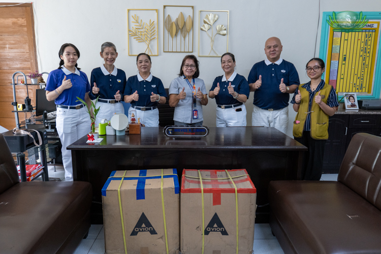 Tzu Chi volunteers and Mrs. Nieves Lising of Antonio Regidor Elementary School give a thumbs-up after the school received 5,000 face masks. 