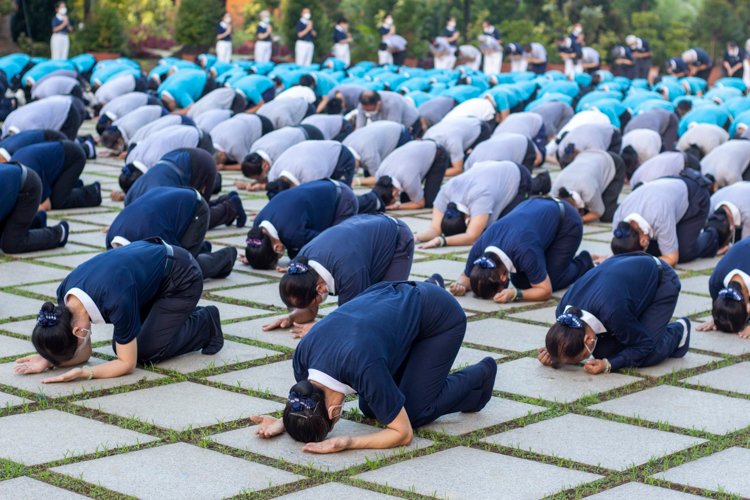 Volunteers bow in full prostration, the ultimate symbol of humility. 【Photo by Matt Serrano】