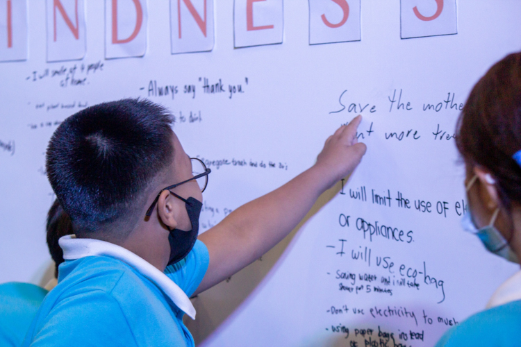 Tzu Chi scholars approach the white board to write the acts of kindness they can commit to. 【Photo by Marella Saldonido】