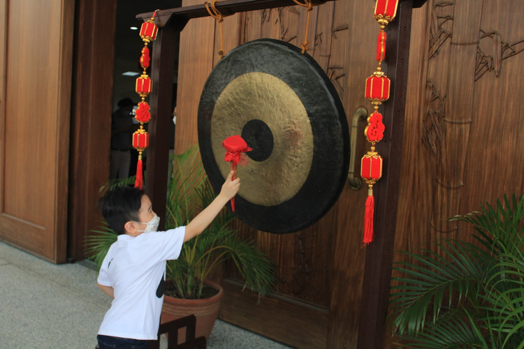 A boy strikes the gong for good luck. 【Photo by Daniel Lazar】