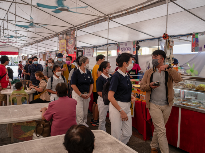 Joshua Demetrio (first from right) tours Tzu Chi volunteers inside the Kyusi Food Bazaar, a source of freshly cooked meals for Quezon City Hall employees, and members of the nearby communities.  【Photo by Daniel Lazar】