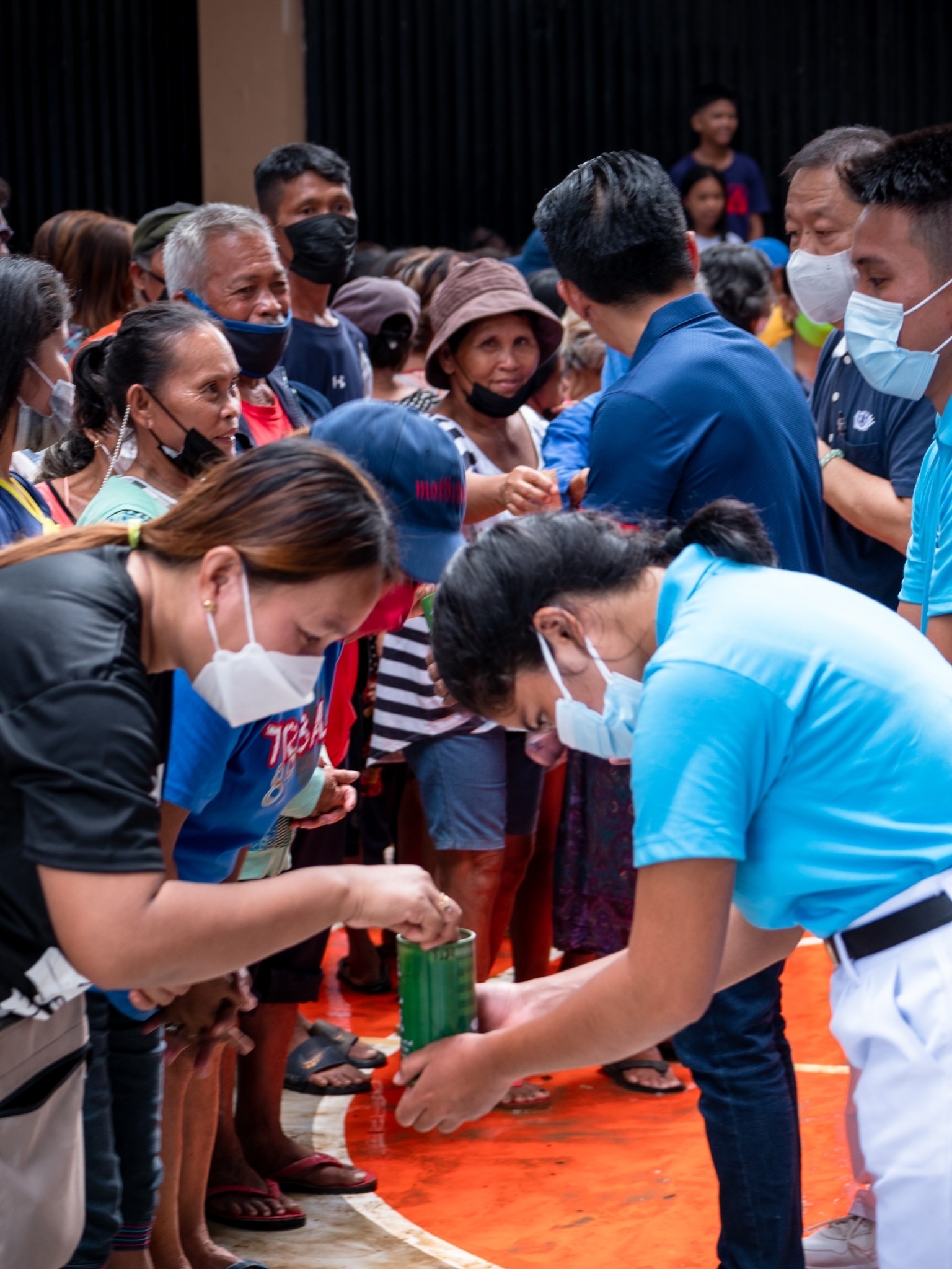 A beneficiary drops her pledge into Tzu Chi’s coin bank. Any amount is welcome as it contributes to helping others in need. 【Photo by Daniel Lazar】