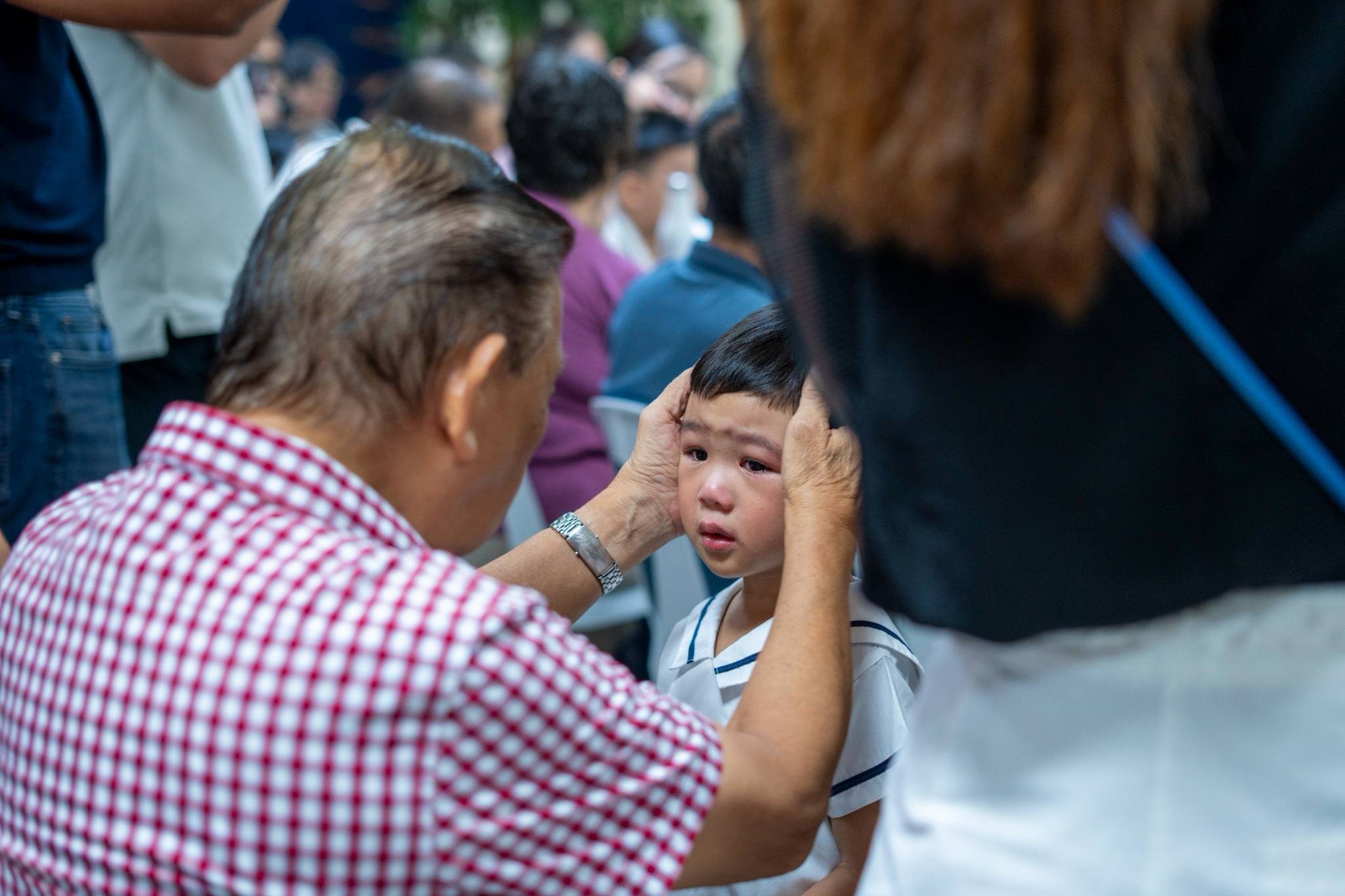 Albino Kaw comforts his grandson Odain before their performance. 