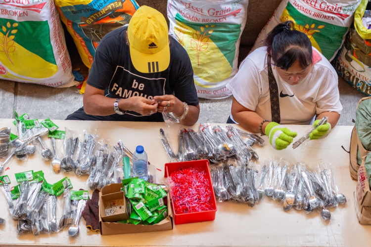Marikina volunteers pack sets of eating utensils.