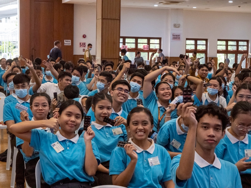 Tzu Chi scholars wave the packs of vitamins they received from a generous sponsor.