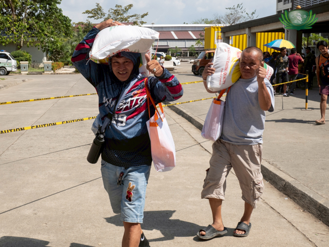 Two men say "thank you" with their thumbs.