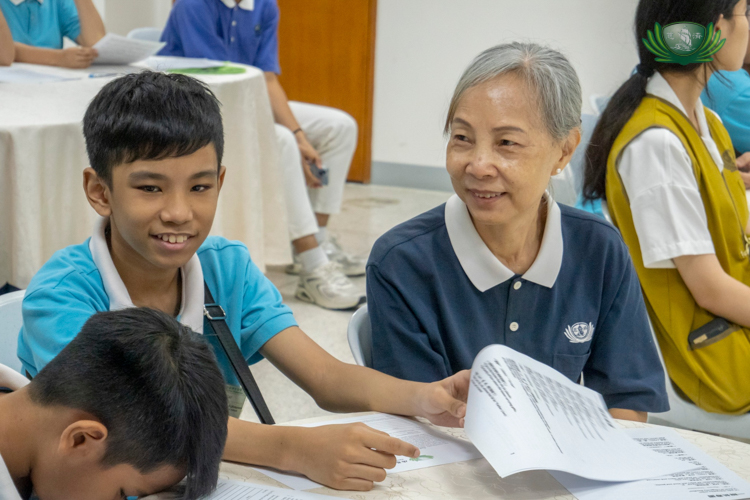 A Tzu Chi volunteer and scholar participate in the script-reading activity.