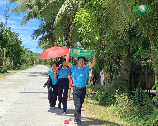 Scholars remain positive and joyful as they walk through the streets of Palo, Leyte, during their fundraising campaign.