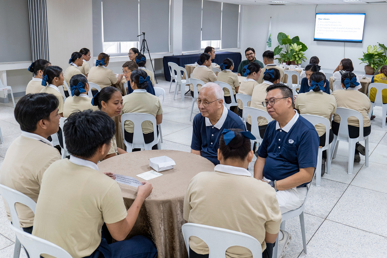 Tzu Chi volunteers and Lao Foundation representatives listen attentively as scholars share their stories during a round-robin table discussion.
