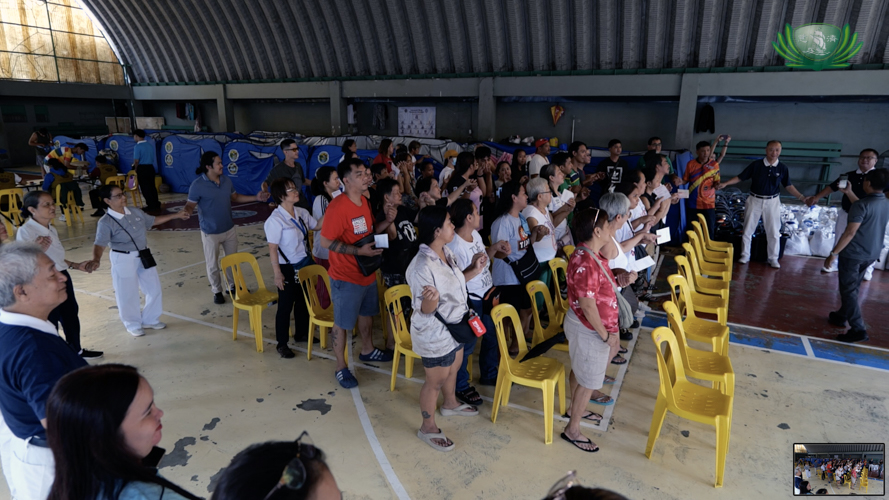 A heartfelt moment, beneficiaries and volunteers hold hands as they sing “One Family.”
