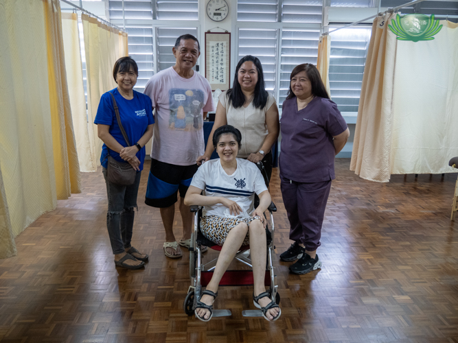 At Tzu Chi’s free clinic, Rica Serrano (seated) is joined in a photo shoot by the people who care for her, including her parents, Ricardo and Maribel (center) and Dr. Regina Talavera (right).