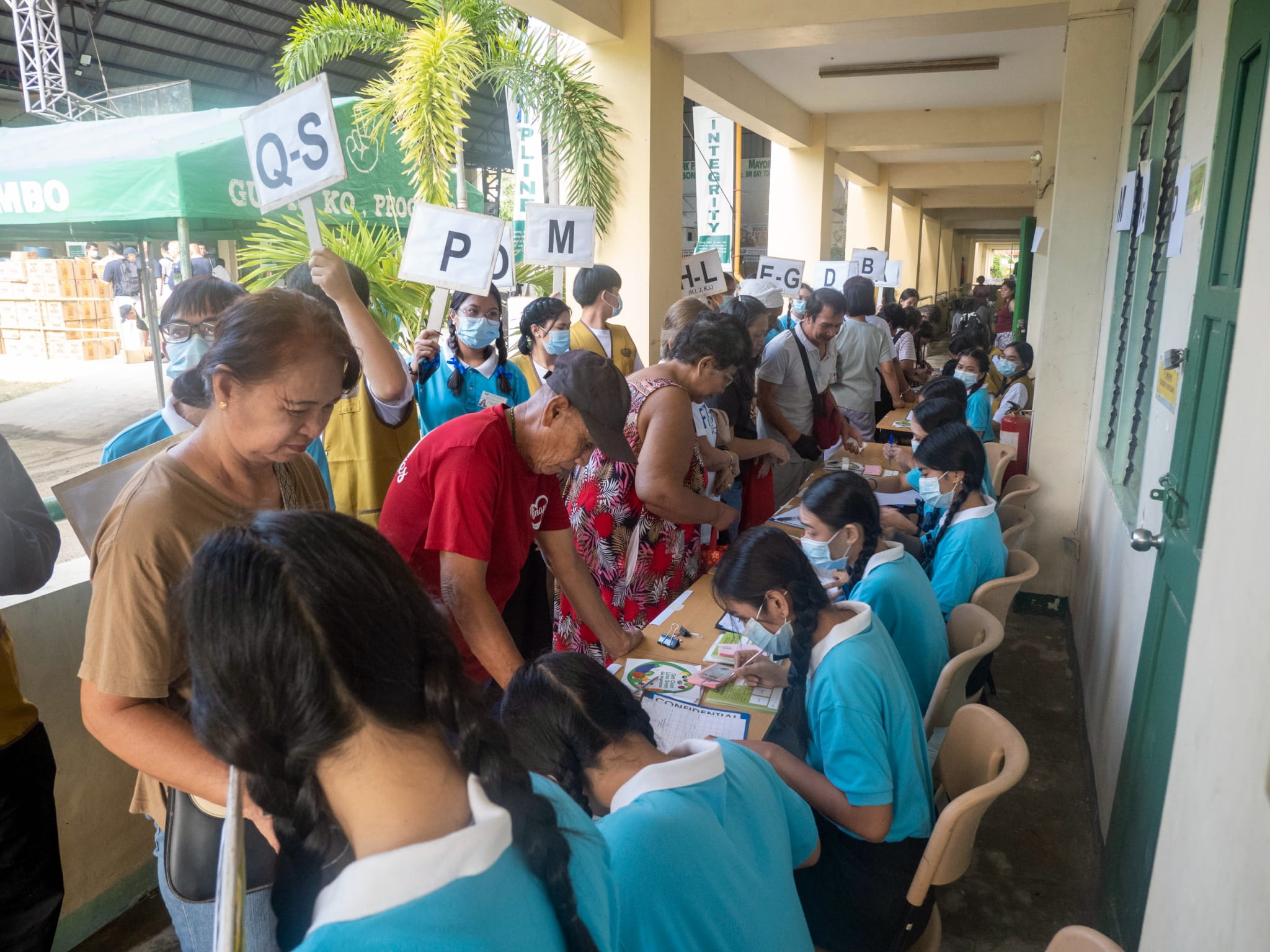 Tzu Chi Pampanga scholars assist at the registration table by issuing stubs to beneficiaries.