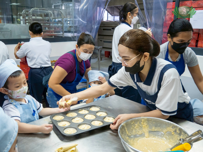 Preschool teacher Marian “Yani” Carpo helps a student with the cupcake trays. 