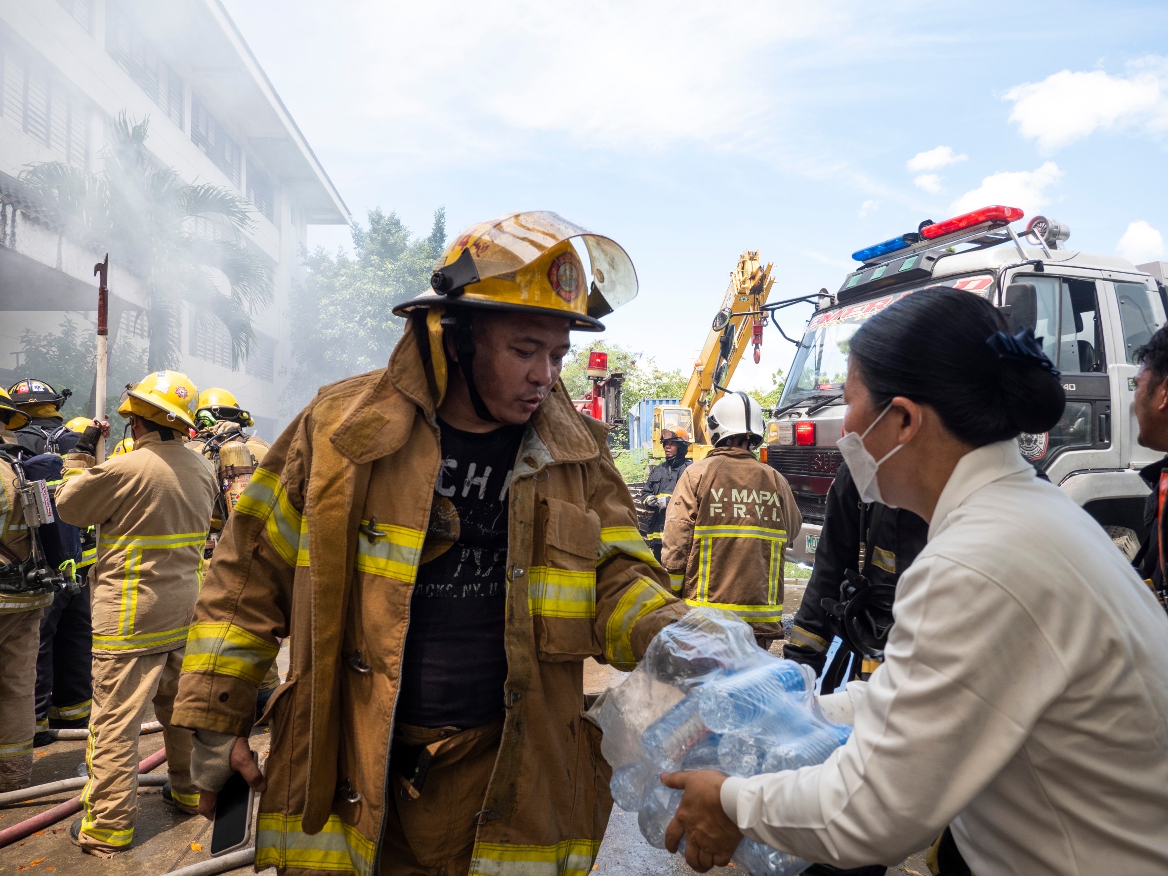 Volunteers distribute water to firefighters. 【Photo by Kendrick Yacuan】