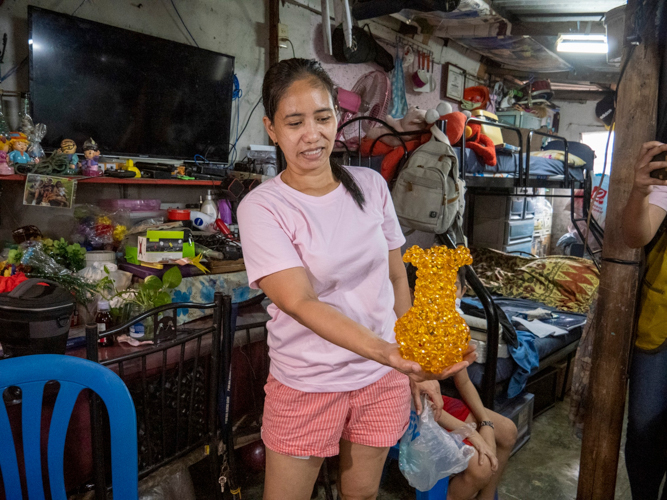 Solo parent Jocelyn Arreza is also a stay-at-home mom, who earns from orders of handmade crafts, like this vase made of crystal beads. She also sews cloth facemasks, makes flowers out of colorful acrylic, and puts together keychains using crystal beads. 【Photo by Matt Serrano】