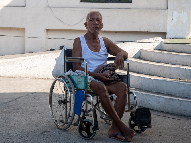 Leo Gabat-bat used his feet to slowly inch his way on his wheelchair from his home in Bangkulasi to the San Lorenzo Ruiz and Companion Martyrs Parish in Kaunlaran Village. The 65-year-old stroke survivor is paralyzed on his right side. Unemployed, he cannot maintain medication for his hypertension and diabetes, much less put food on the table. 