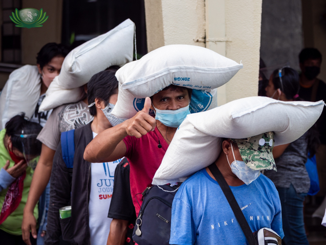 Beneficiaries use their head, so to speak, to carry their sacks of Taiwan rice. 【Photo by Daniel Lazar】