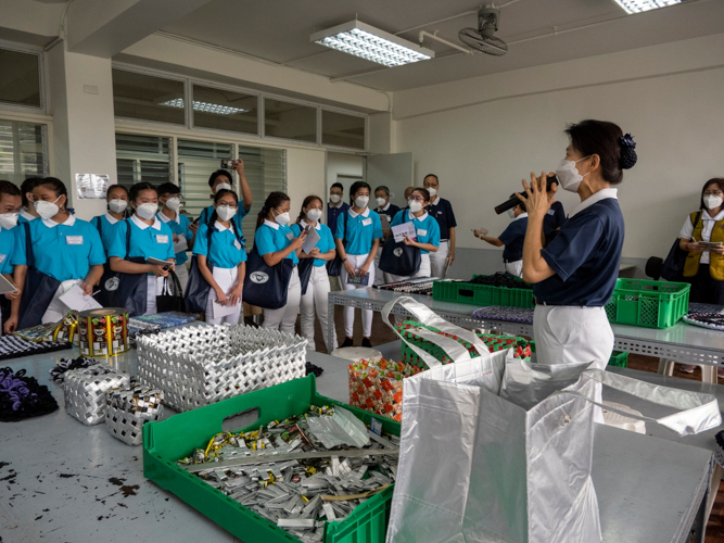 Scholars listen as Tzu Chi Deputy CEO Woon Ng explains the projects of the upcycling center.【Photo by Matt Serrano】