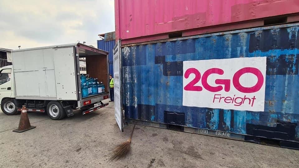Bottled water from a Tzu Chi Foundation truck is transferred to a 2Go container van for transport to Cebu. 