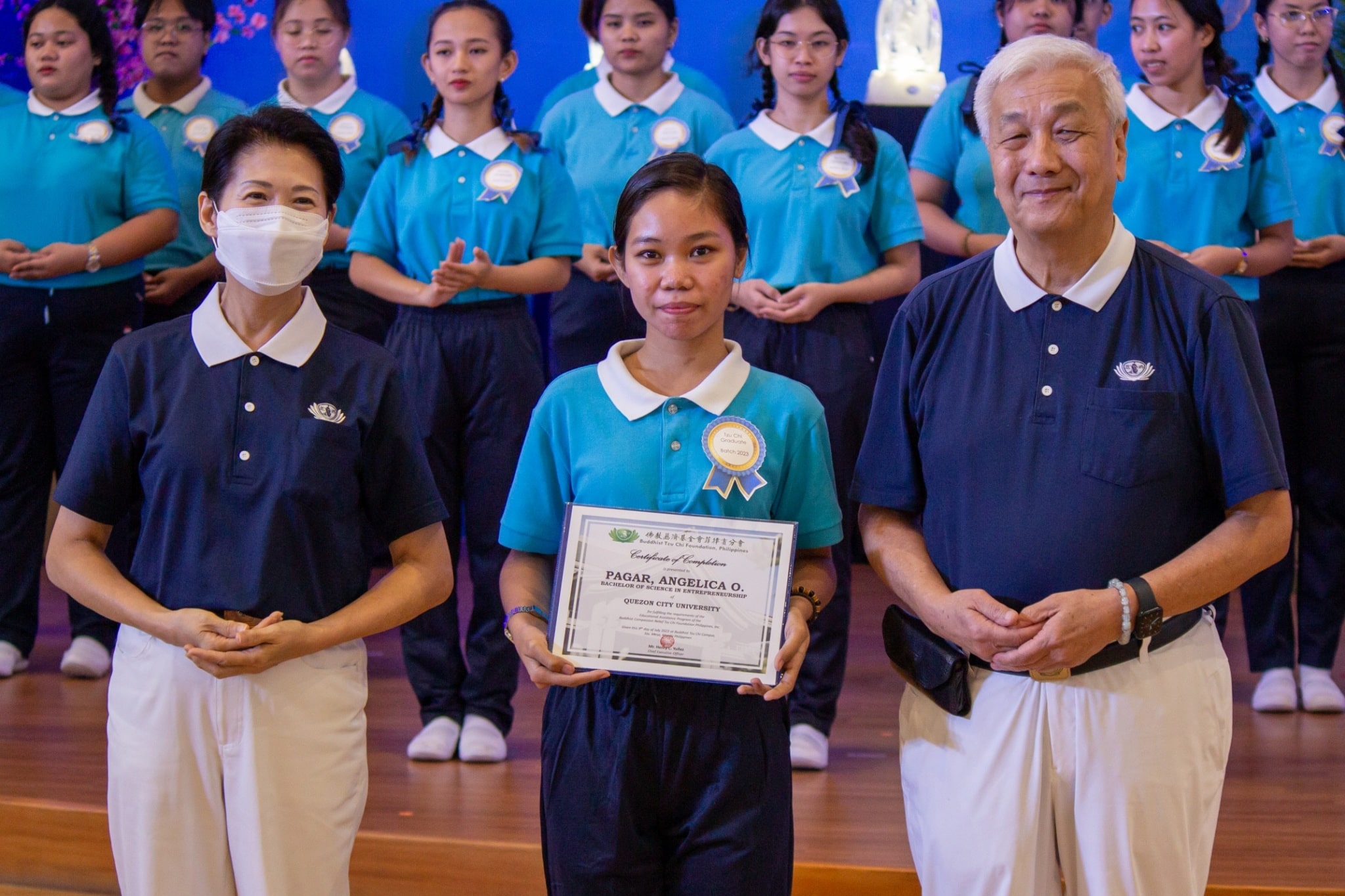 Angelica Pagar receives her certificate of completion from Tzu Chi Philippines CEO Henry Yuñez (right) and Deputy CEO Woon Ng (left). 【Photo by Marella Saldonido】