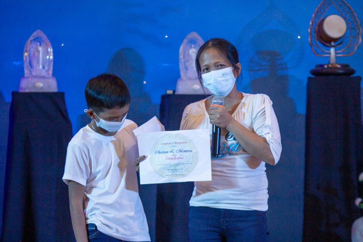 Cecil Memoria (right) accepts a certificate declaring her son Christian a Cancer Survivor. With his treatments over, Cecil has decided to end Tzu Chi’s medical assistance for her son “so that others may receive help for their conditions,” she says. 【Photo by Marella Saldonido】