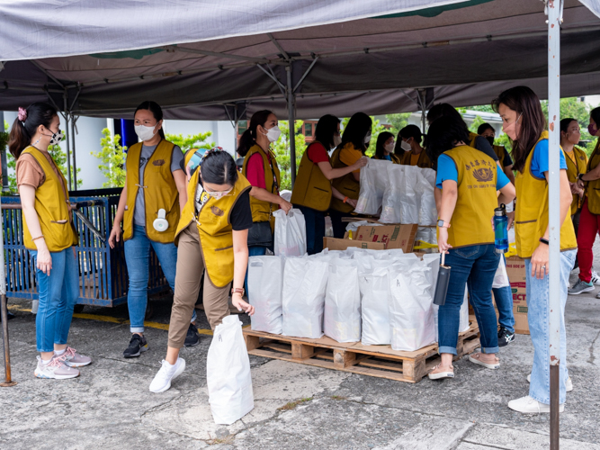 Employees from Globe’s finance group assist in the rice relief distribution for scholars.【Photo by Daniel Lazar】