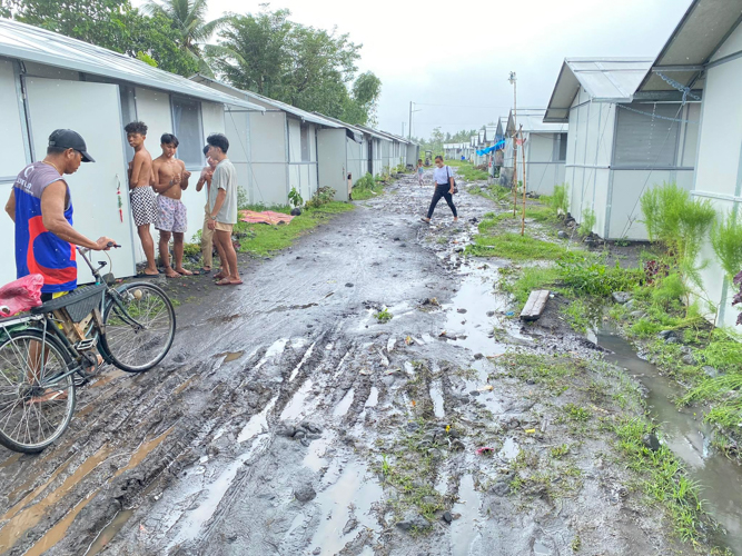 Residents at Tzu Chi Great Love Village in Bicol contend with muddy grounds following Typhoon Paeng’s torrential rains. 
