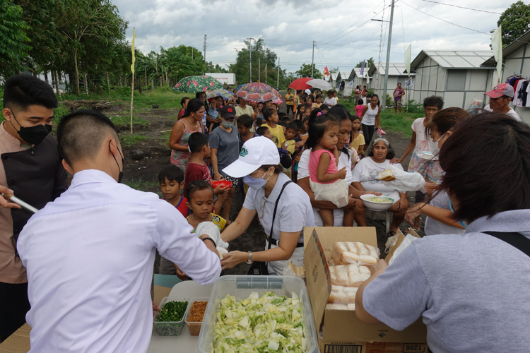 Tzu Chi volunteers in Bicol organize the distribution of hot porridge and bread for 100 families of Tzu Chi Great Love Village in Tabaco, Albay. 