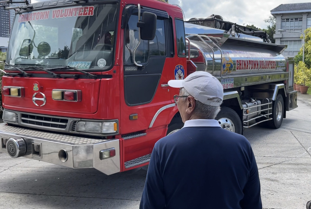 Tzu Chi Foundation Philippines CEO looks on as firefighters arrive on the scene. 【Photo by Judy Lao】