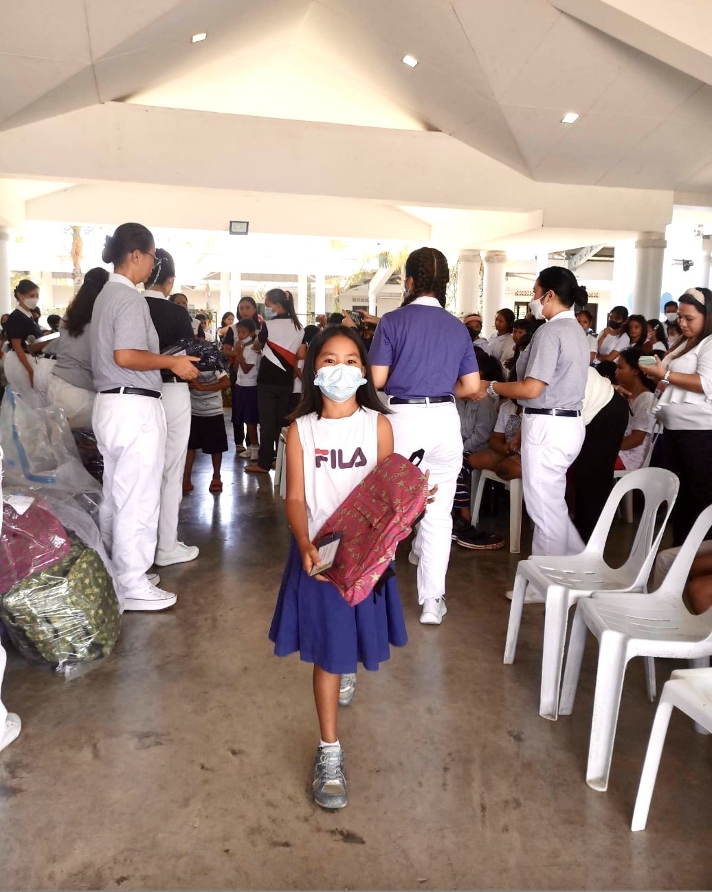 A student receives a backpack from Tzu Chi Davao volunteers who dropped by Mangayon Elementary School on June 9, 2023. (Photo from Mangayon Elementary School’s Facebook Page)