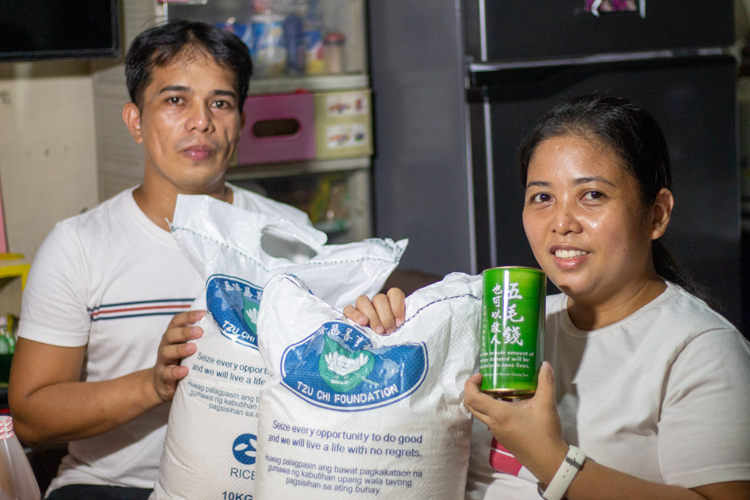 Jay-R and Maricris Custodio are happy to take home additional assistance from Tzu Chi.【Photo by Harold Alzaga】