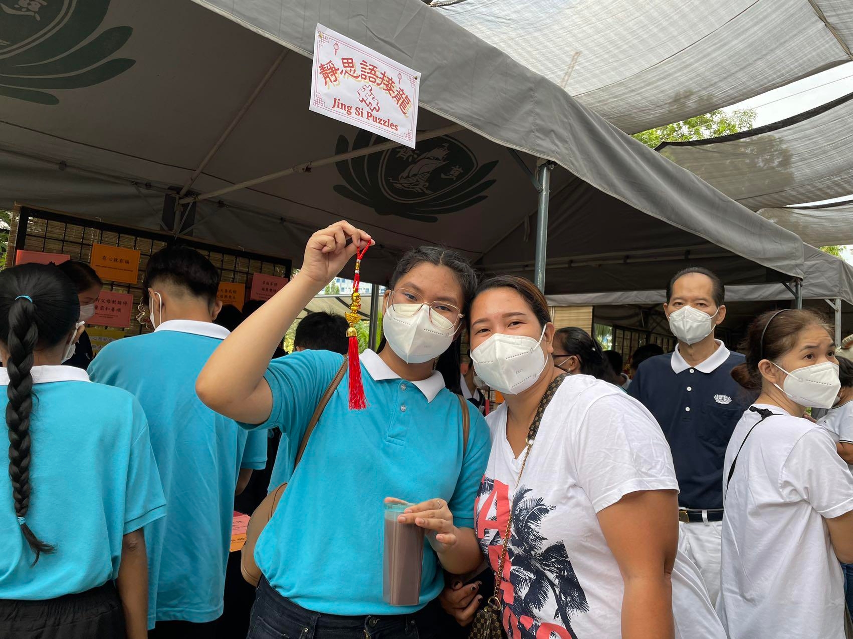  A Tzu Chi scholar displays a lucky charm from a game booth run by Tzu Chi youth. 