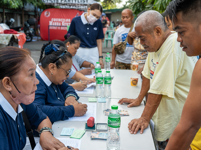Tzu Chi volunteers talk to beneficiaries as they give out the stubs for the relief goods. 【Photo by Marella Saldonido】
