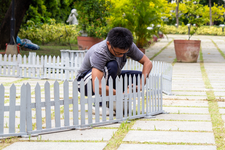 A volunteer installs the fence that will surround the round platform.【Photo by Marella Saldonido】
