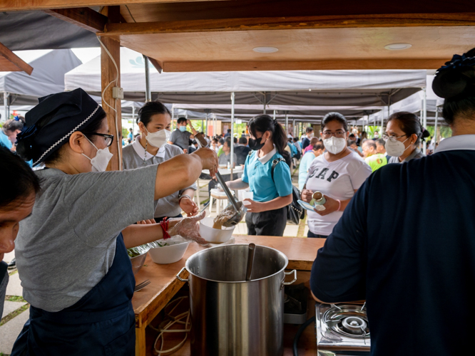 A volunteer serves miswa, whose noodles symbolize long life, to guests. 【Photo by Daniel Lazar】