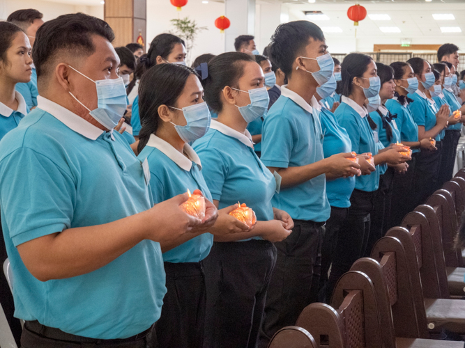 Participants raise a lighted candle as they pray for better things ahead.