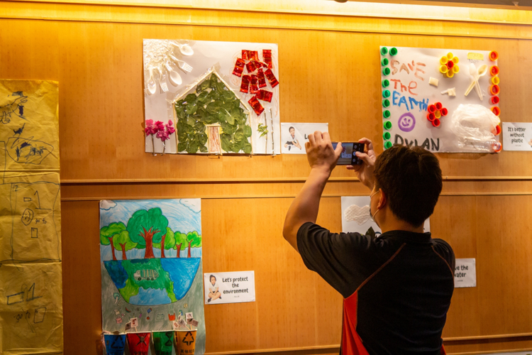 A parent takes a snapshot of his child’s artwork inspired by their lessons on the environment. 【Photo by Marella Saldonido】