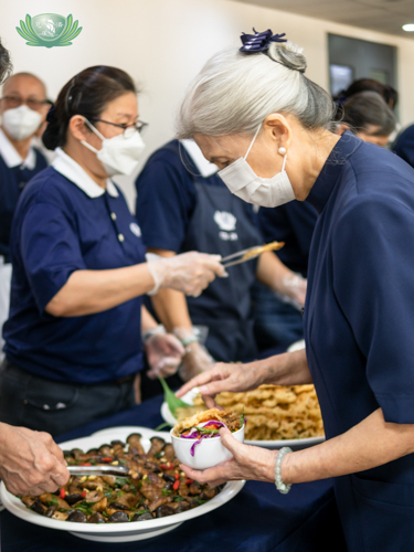 A volunteer helps herself to food from the vegetarian buffet. 【Photo by Daniel Lazar】