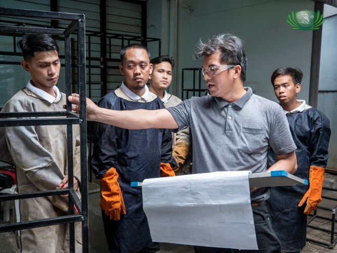 Tzu Chi Technical-Vocational Program trainer Elpidio Valdez Jr. (in gray) guides scholars enrolled in the foundation’s welding course.