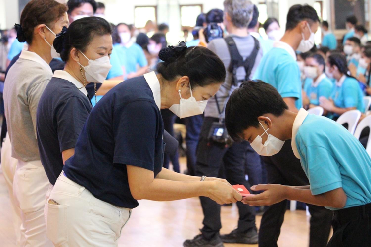 Tzu Chi Education Committee Head Volunteer Rosa So (third from left) presents a Tzu Chi scholar with angpao. 【Photo by Kenley Yap Wong】