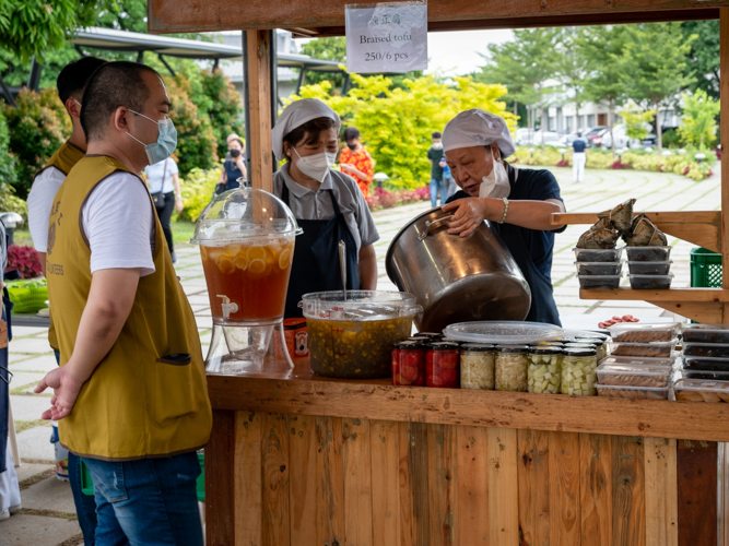 David Anthony Tan (left) checks on his stall at the charity bazaar organized by Tzu Chi Foundation on July 30 and 31. 【Photo by Daniel Lazar】