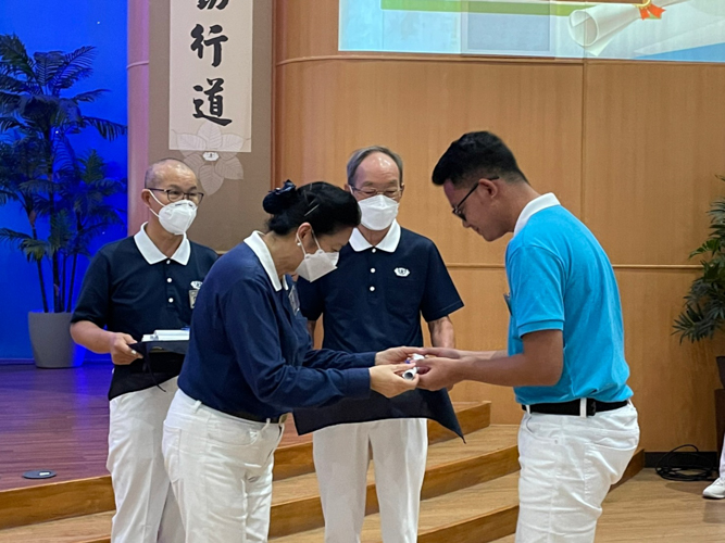 A scholar receives a symbolic diploma from Tzu Chi Education Committee volunteer Rosa So.【Photo by Daniel Lazar】