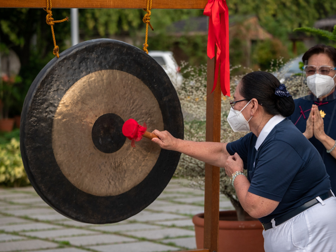 Guests and volunteers make a wish before striking a gong. 【Photo by Daniel Lazar】