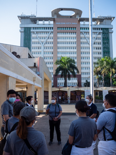 Outside Quezon City Hall, Tzu Chi’s Dolly Alegado Cruz (center) briefs volunteers before their meeting with officers of QC’s Sustainable Development Affairs. 【Photo by Daniel Lazar】