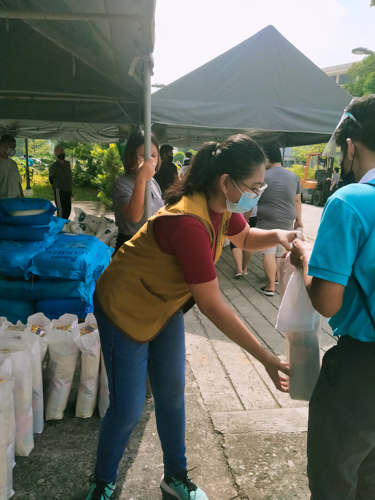 Catherine Jill Cilla hands out a bag of groceries to a Tzu Chi scholar. “I didn’t feel tired at all. I’m happy seeing the smiles of the beneficiaries who are very thankful for the help.”