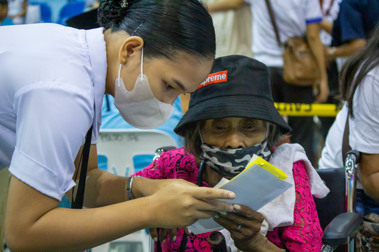 A volunteer nurse gives Melba Pelaez a prescription for her painful and swelling hands and feet. 【Photo by Marella Saldonido】