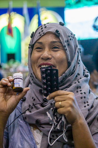 Minda Ramos excitedly shows the free medicines she received. “This is truly a big help for me. They gave me this medicine for my headaches and sleeping problems, and vitamins that will probably last for a month.” 【Photo by Marella Saldonido】