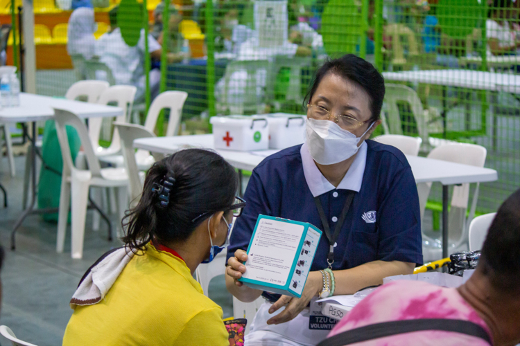 Patients sample reading glasses with the help of a Tzu Chi volunteer. 【Photo by Marella Saldonido】