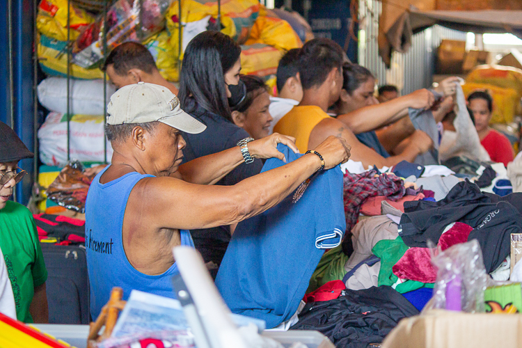 A customer searches through the piles of clothing for sale. 【Photo by Marella Saldonido】